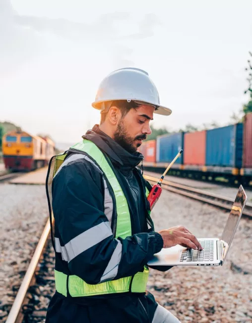 Man on rail tracks with laptop